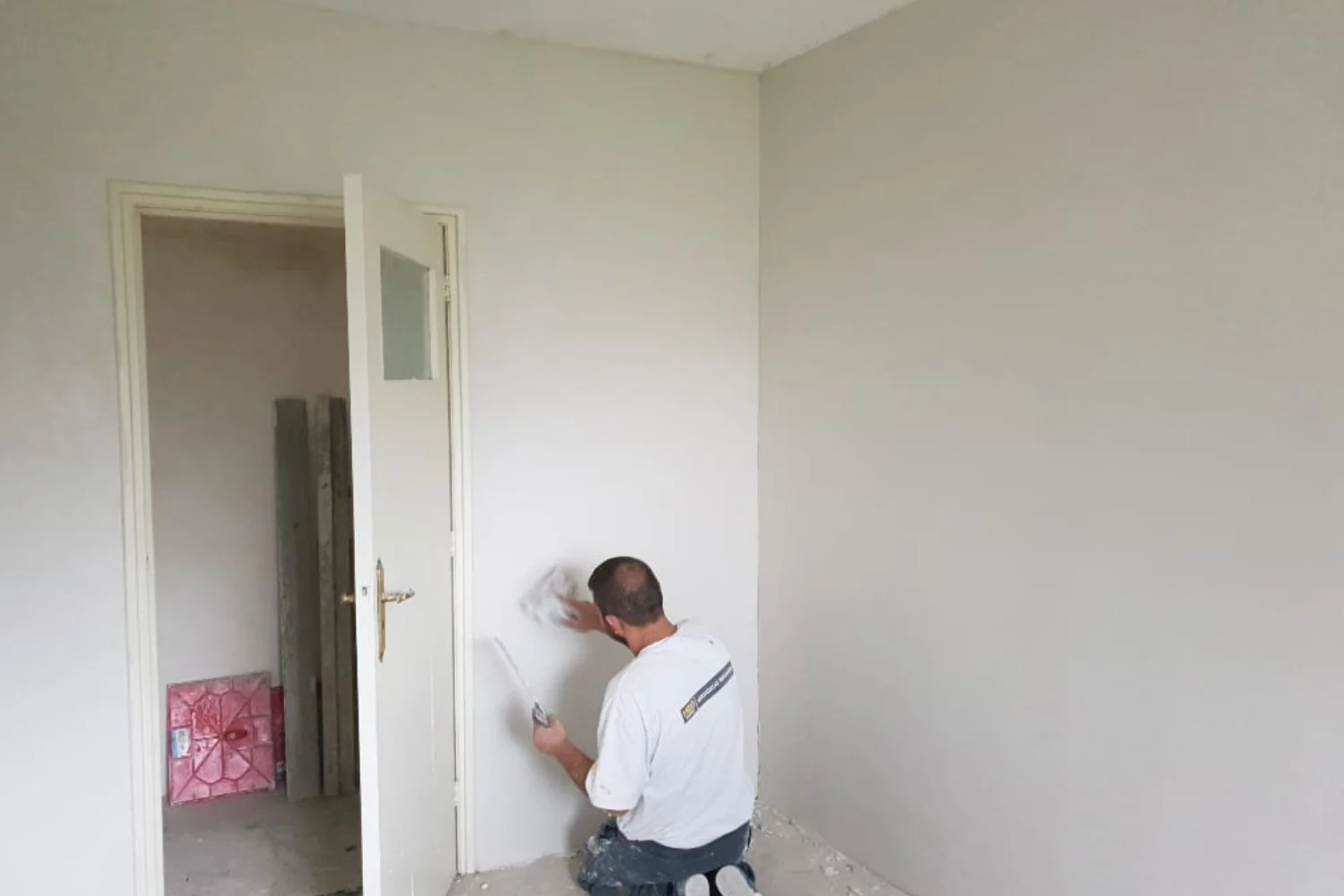 Man schildert muur in lege kamer