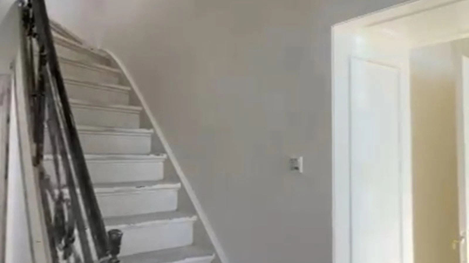 White staircase in a minimalist interior with grey-green walls.
