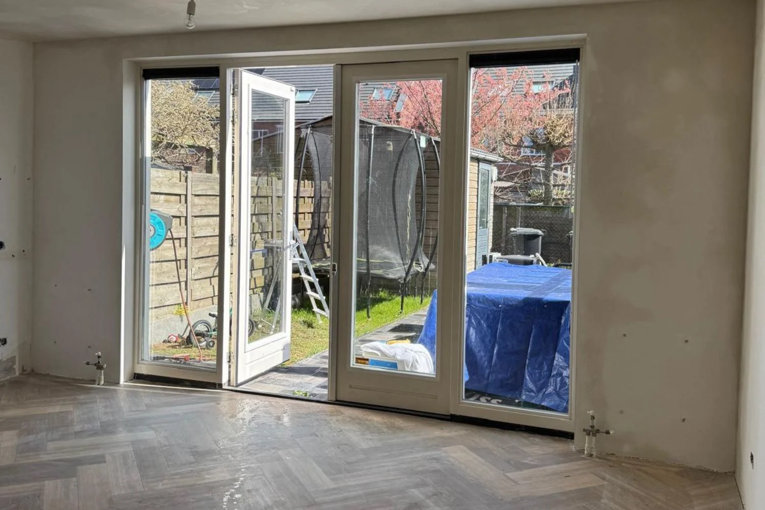 Living room with open patio doors and garden view.